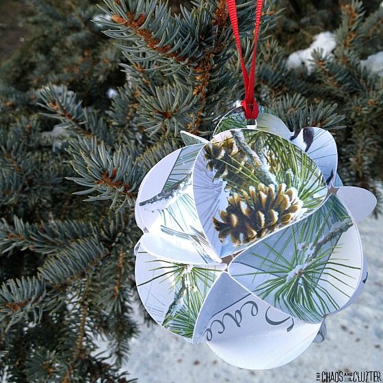 a paper ornament hangs on a pine tree