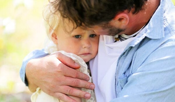a brown haired father is holding his blond daughter. The text reads "5 Things to Say to Your Anxious Toddler"