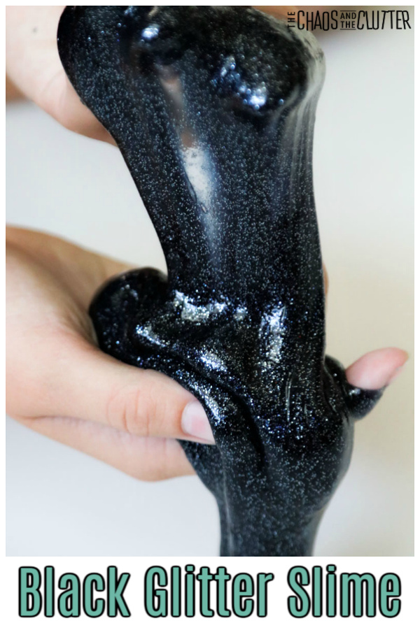 two hands holding black glitter slime