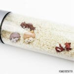 clear bottle filled with dry rice and forest animal buttons