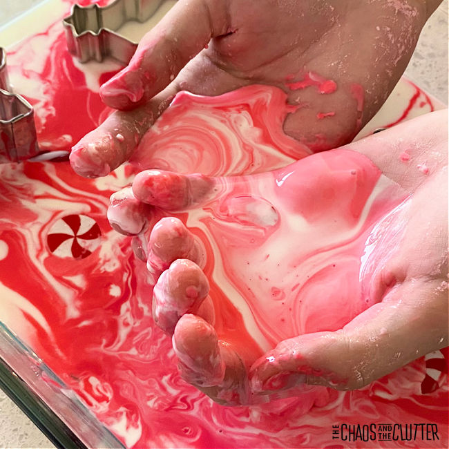 hands holding red and white swirls of liquid