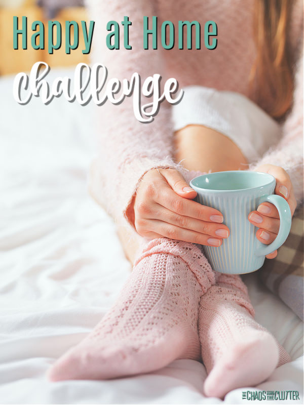 woman's socked feet are visible as her hands hold a teal mug. Text reads "Happy at Home Challenge"