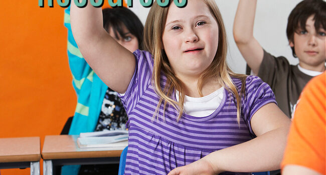 girl in striped purple shirt has her hand raised in class