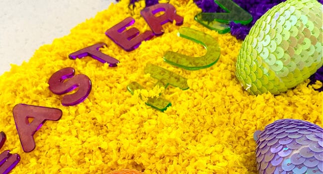 yellow and purple with toy sparkly eggs and the letters to spell Easter Egg Hunt