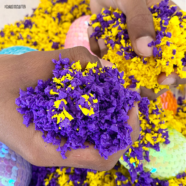 hand squishes purple and yellow Pluffle