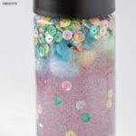 blue plush mini chick and pastel sequins in a bottle with clear liquid and glitter