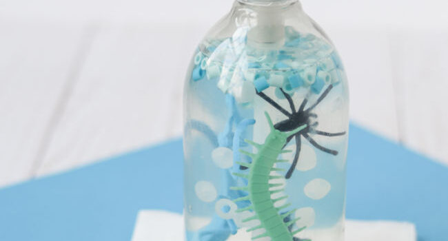 soap dispenser with clear soap and blue and green plastic bugs in it