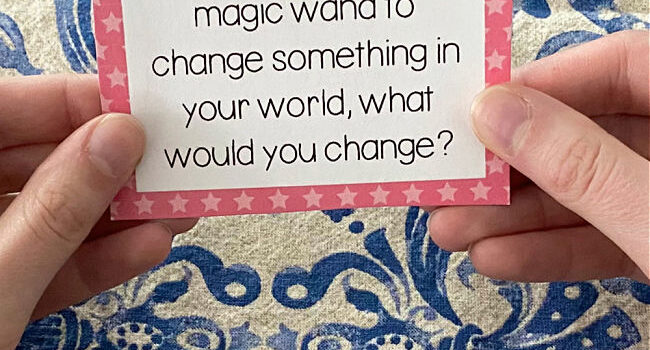 hands holding a card with a question typed on it