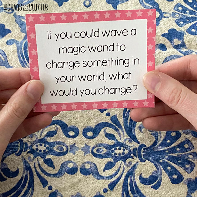 hands holding a card with a question typed on it