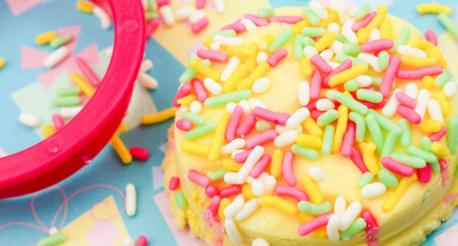 pink circle cookie cutter next to yellow playdough covered in candy sprinkles