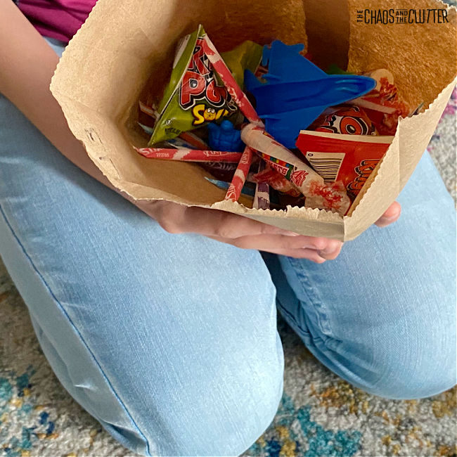 brown paper bag filled with candy and small toys
